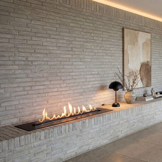 Modern living room with stone wall, fireplace, and dining area.