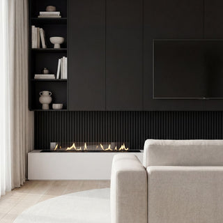 Modern living room with a white sofa, round rug, and black wall with a fireplace.
