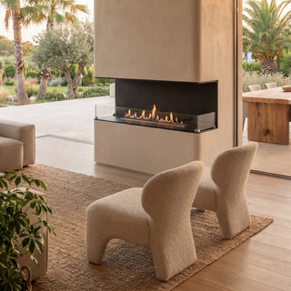 Modern living room with fireplace, chairs, and outdoor view