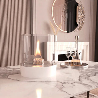 Modern dining room with marble table, fire pit, and decorative mirror.